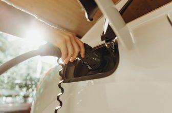 Coche eléctrico conectado a la corriente en un entorno exterior
